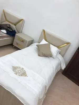 a bedroom with a white bed with white sheets and pillows at بيت العُمري (ام قيس) in Um Qeis