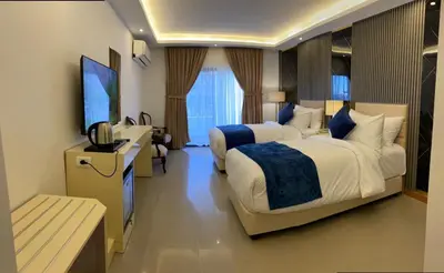 a hotel room with two beds and a flat screen tv at The RN Hotels in Wadi Musa