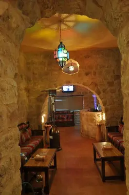 a room with couches and tables in a stone building at The RN Hotels in Wadi Musa