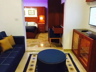 a living room with a blue couch and a bedroom at The Royal Luxury Lion Patio in Amman
