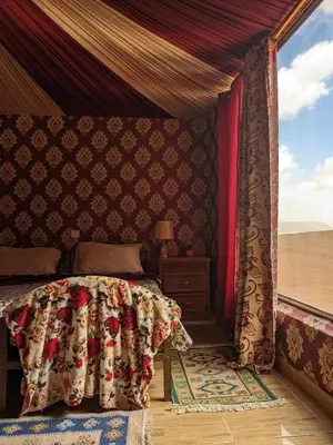 a bedroom with a bed and a window at Why not camp in Wadi Rum