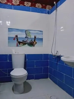 a blue tiled bathroom with a toilet and a sink at Why not camp in Wadi Rum