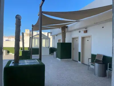 a patio with a canopy and a bench and a building at Dweik Rooftop in Aqaba