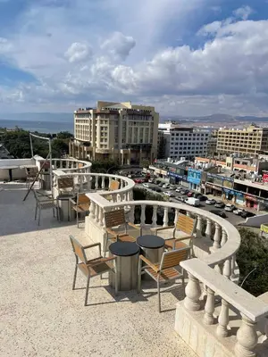 a group of chairs and tables on top of a building at Dweik Rooftop in Aqaba