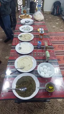 a long table with plates of food on it at Wadi Rum Khalifa Camp in Wadi Rum
