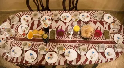 a table with cups and saucers and plates on it at Student House in Madaba