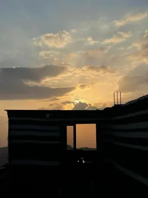 a silhouette of a building with the sunset in the background at Plaza View Hostel in Taiyiba