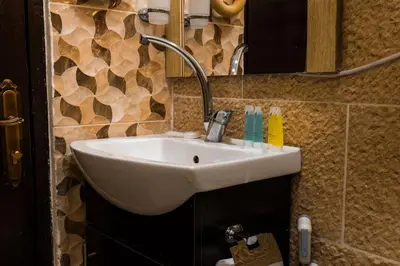 a bathroom with a white sink and a mirror at Plaza View Hostel in Taiyiba