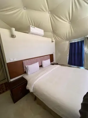 a bed in a tent with two pillows on it at Rum Serena Camp in Wadi Rum