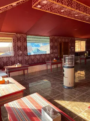 a room with tables and windows in a building at Rum Serena Camp in Wadi Rum