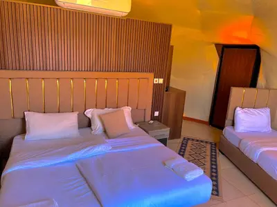 a bedroom with two beds with blue sheets and pillows at Arjowana Luxury Camp & Bubbles Hotel in Wadi Rum