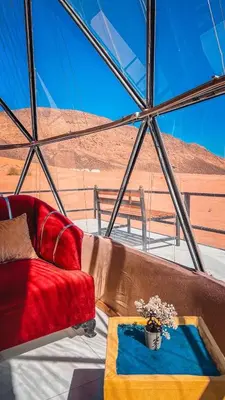 a living room on a boat with a red couch at Arjowana Luxury Camp & Bubbles Hotel in Wadi Rum