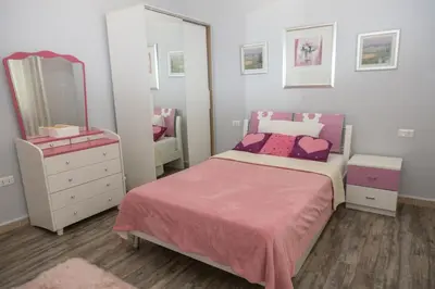 a bedroom with a bed and a dresser and a mirror at Hanan Residence 01 - 3BR, Der Ghbar 165m2 in Amman