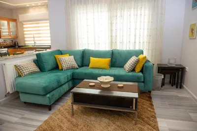 a living room with a green couch and a coffee table at Hanan Residence 01 - 3BR, Der Ghbar 165m2 in Amman