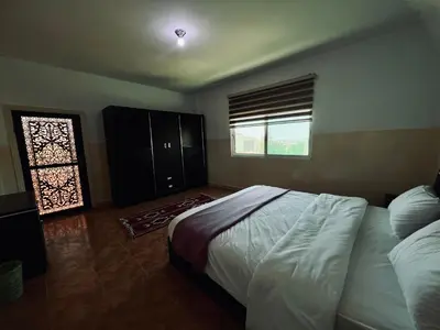 a bedroom with a large bed and a window at Petra Gold Inn Apartments in Wadi Musa