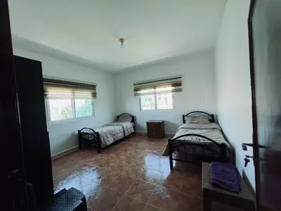 a room with two beds and two windows at Petra Gold Inn Apartments in Wadi Musa