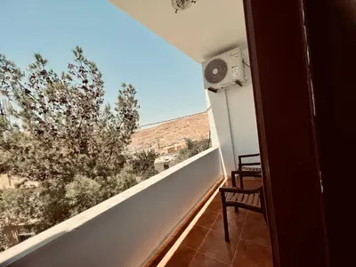 a balcony with a view of a tree at Petra Gold Inn Apartments in Wadi Musa