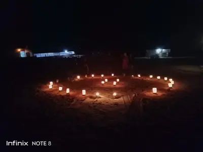 a circle of candles in the sand at night at Nafa Rum Camp in Wadi Rum