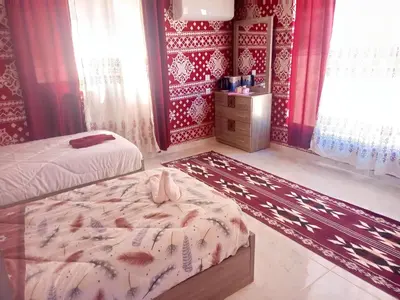a bedroom with two beds and a dresser in it at Nafa Rum Camp in Wadi Rum