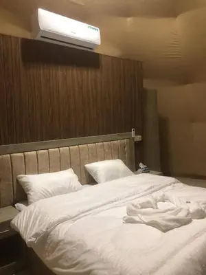 a bedroom with a white bed with a light on it at Salma Desert Camp in Wadi Rum