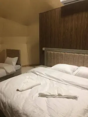 a large white bed in a bedroom with a headboard at Salma Desert Camp in Wadi Rum
