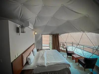 a bedroom with a bed and a swimming pool at Tower Rum Camb in Wadi Rum