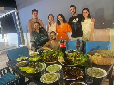a group of people standing around a table with food at lacasa chalet private With a panoramic view of the DeadSea in Sowayma