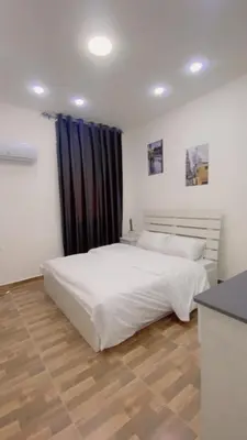 a bedroom with a white bed and a black curtain at lacasa chalet private With a panoramic view of the DeadSea in Sowayma