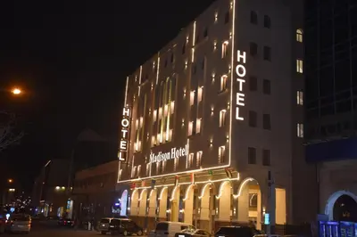 a building with a sign on the side of it at night at Madison Hotel in Amman