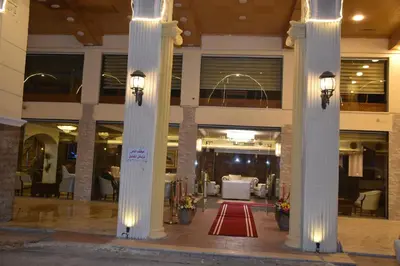 a building with columns with a red rug in the middle at Madison Hotel in Amman