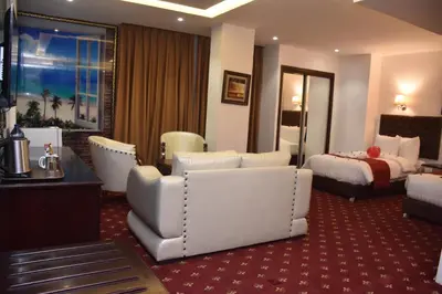 a hotel room with a bedroom and a bed at Madison Hotel in Amman