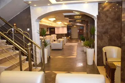 a lobby with chairs and a staircase in a restaurant at Madison Hotel in Amman