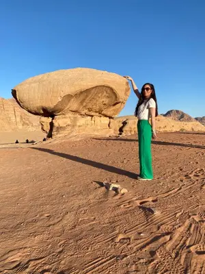 a woman standing in the sand in the desert at Youssef camp Wadi Rum in Wadi Rum
