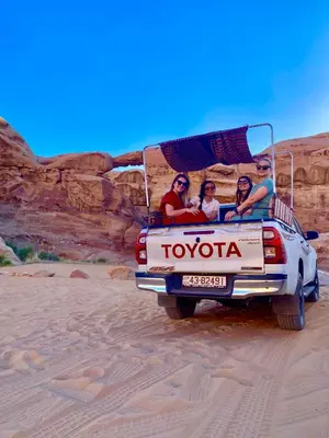 a group of people in the back of a truck in the desert at Youssef camp Wadi Rum in Wadi Rum