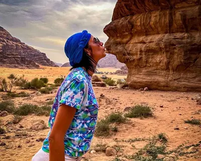 a woman in a blue hijab kissing in the desert at Mahmmad Luxury Camp in Wadi Rum