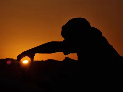 a silhouette of a person with the sunset in the background at Mahmmad Luxury Camp in Wadi Rum