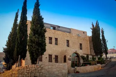 a stone building with trees in front of it at Petra fort hotel in Wadi Musa