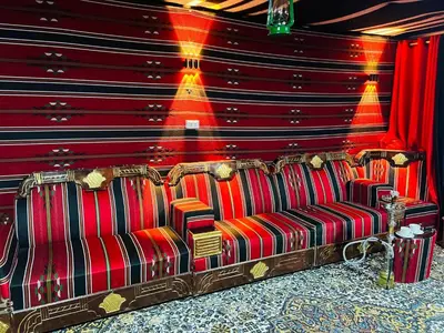 a couch in a room with a red wall at Petra fort hotel in Wadi Musa