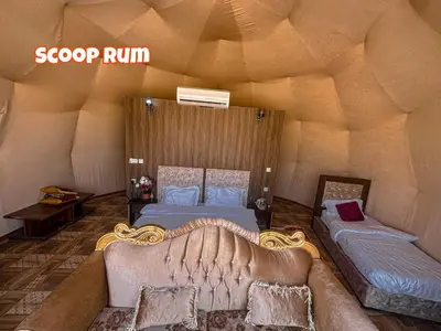 a room with two beds and a couch in a igloo at Scoop Rum in Wadi Rum