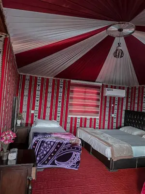 two beds in a room with a tent at Scoop Rum in Wadi Rum