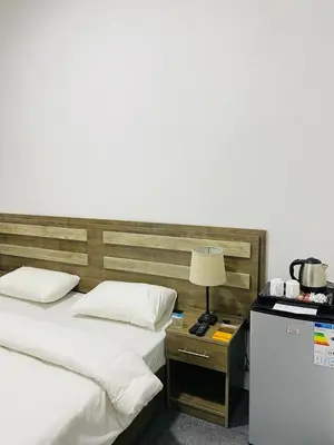 a bedroom with two beds and a table with a lamp at Grandpa House in Wadi Musa