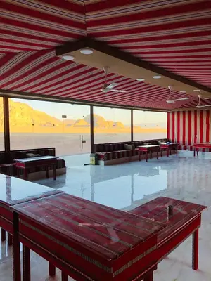 a large room with tables and couches in a building at Wadi rum Wild life camp in Wadi Rum