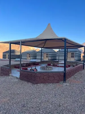 a large tent with a fire pit in the desert at Wadi rum Wild life camp in Wadi Rum