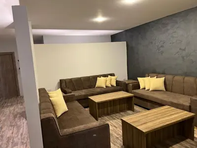 a living room with two couches and a table at Caprios motel in Al Qasţal
