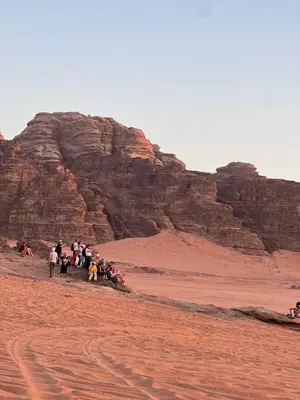 a group of people walking in the desert at Wadi Rum Cream in Wadi Rum