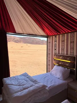 a bed in a tent with a view of the desert at Wadi Rum Cream in Wadi Rum