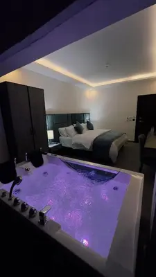 a room with a bathtub with a bed in the background at La Vie Boutique Hotel in Wadi Musa
