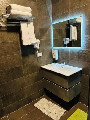a bathroom with a sink and a mirror and towels at La Vie Boutique Hotel in Wadi Musa