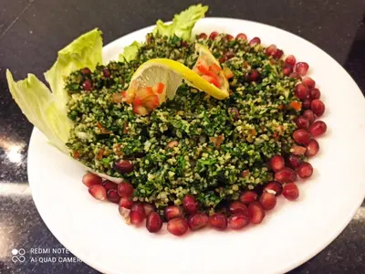 a white plate with a salad with grapes and lettuce at La Vie Boutique Hotel in Wadi Musa