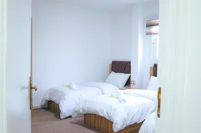 a bedroom with two beds with white sheets at Petra Wow Hostel in Wadi Musa